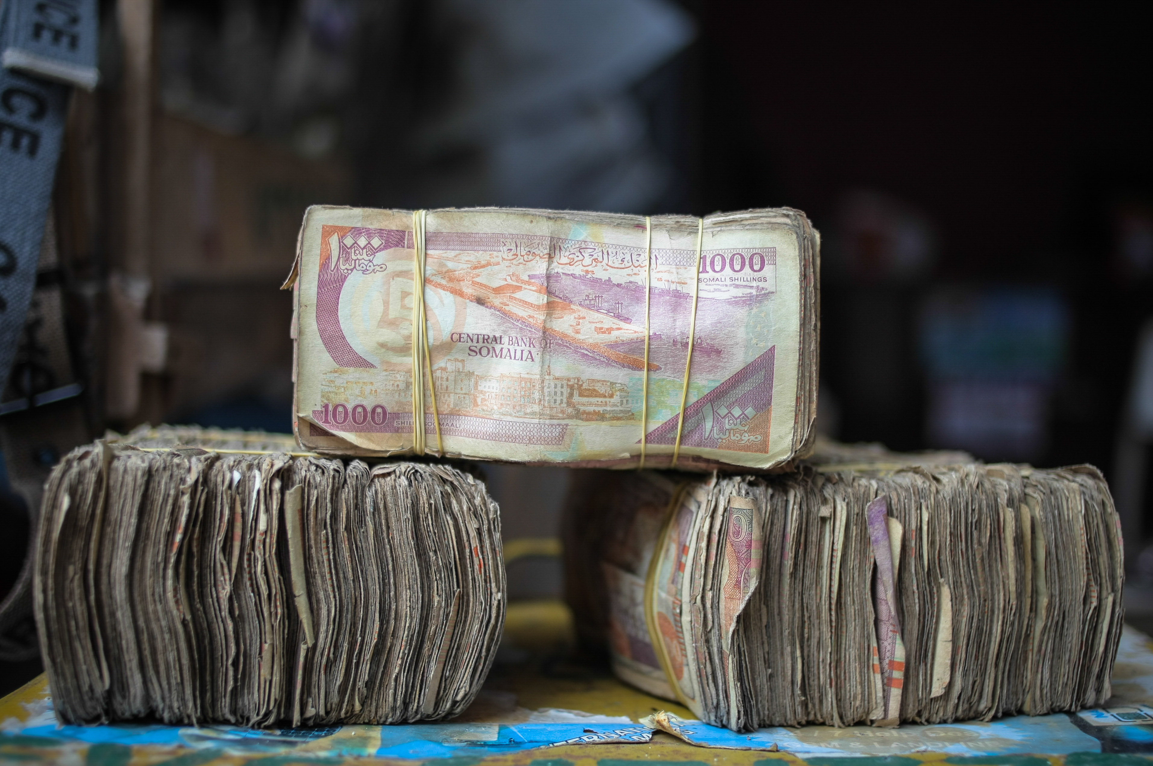 SOMALIA, Mogadishu: In a photograph taken 23 October 2013 and released by the African Union-United Nations Information Support Team 25 October, bundles of Somali shilling notes are seen at a money exchangers stall on the streets of the Somali capital Mogadishu. Millions of people in the Horn of Africa nation Somalia rely on money sent from their relatives and friends abroad in the form of remittances in order to survive, but it is feared that a decision by Barclays Bank to close the accounts of some of the biggest Somali money transfer firms – due to be announced this week - will have a devastating effect on the country and its people. According to the United Nations Development Programme (UNDP), an estimated $1.6 billion US dollars is sent back annually by Somalis living in Europe and North America. Some money transfer companies in Somalia have been accused of being used by pirates to launder money received form ransoms as well as used by Al Qaeda-affiliated extremist group al Shabaab group to fund their terrorist activities and operations in Somalia and the wider East African region. AU/UN IST PHOTO / STUART PRICE.